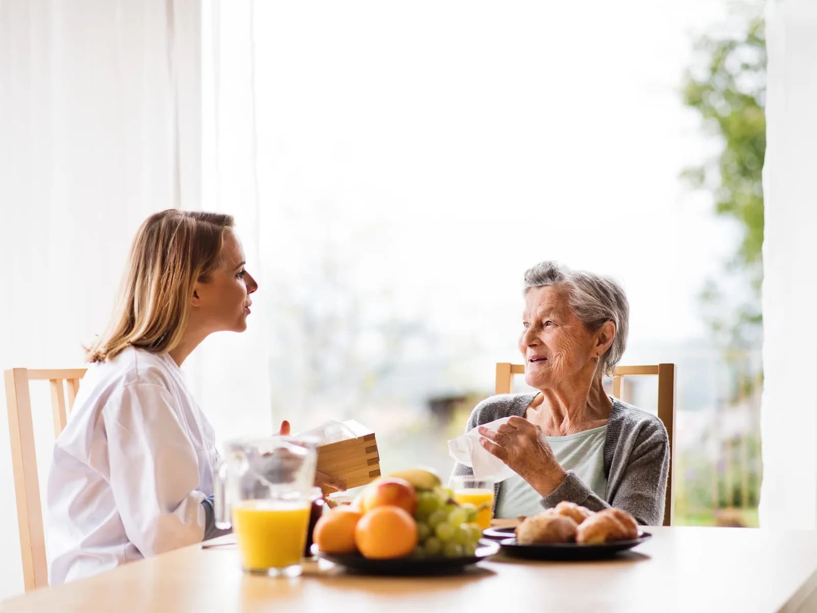 Home care worker speaking with an older woman during a visit