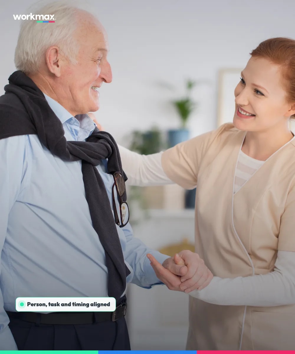 Care assistant supporting an older man during a home visit