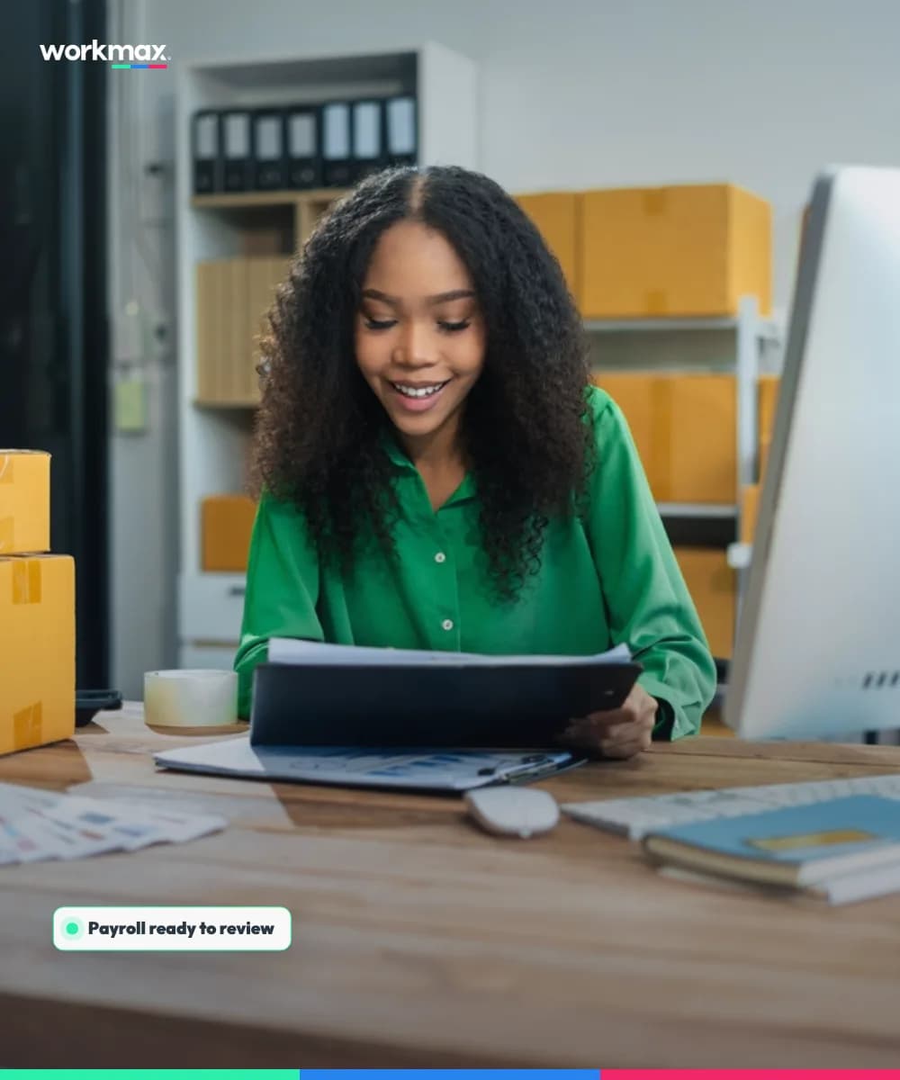 Small-business owner smiling while reviewing work records at her desk